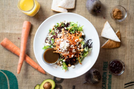 VILLAGE Salad - grated beets + carrots, chickpeas, feta, toasted almonds, sunflower seeds, artisan greens, curried balsamic dressing